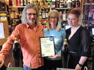 Darren, Nicci and Gemma show off the Pub of the Season plaque behind the bar at the Wuthering Heights, Saturday 9th February 2019